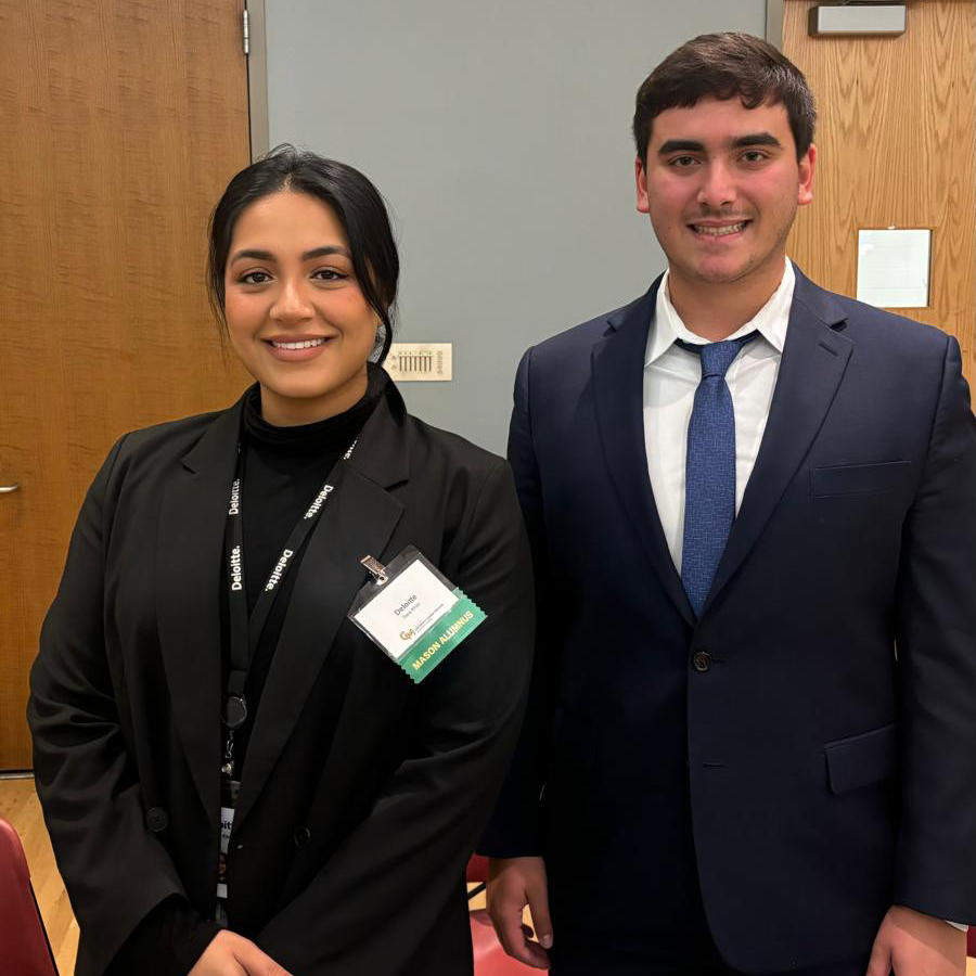 Deloitte employers in professional attire smile during a career event at George Mason University. 